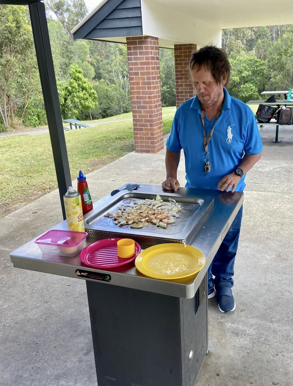 Volunteer cooking a BBQ at a community park event