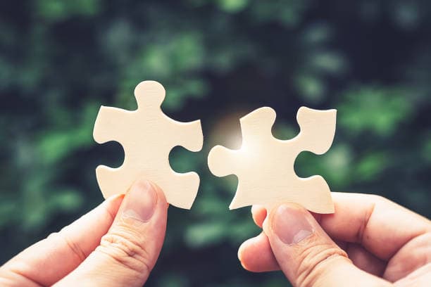 Two puzzle pieces coming together, representing coordinating supports